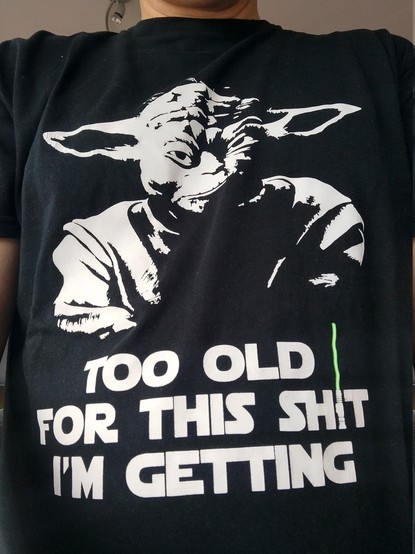Ein schwarzes T-Shirt mit einem schlecht gelaunten und etwas zerknitterten Yoda und dem Spruch 