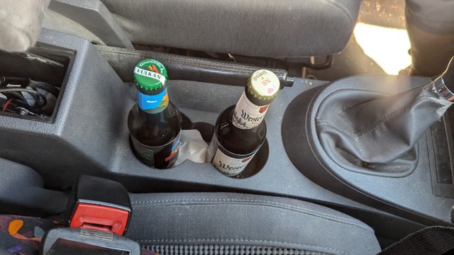 Zwei Bierflaschen im Getränkehalter des Autos, einmal Westerwald -Bräu, einmal Vulkan.