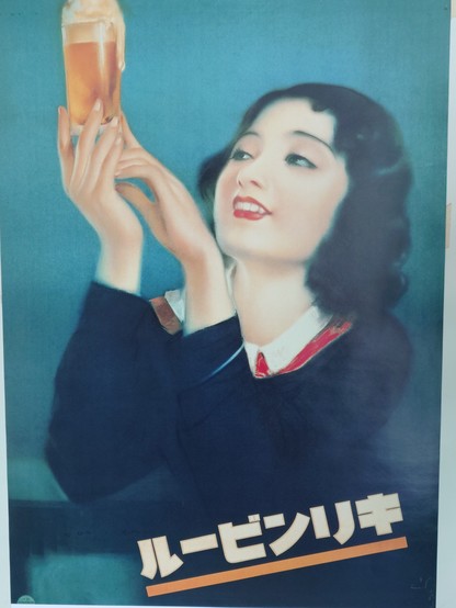 Ad poster for Kirin Beer with a young girl holding a glass of beer. Since the the poster is from the 1910/20s the name of the beer is written from right to left, so the other way it usually is written today. 