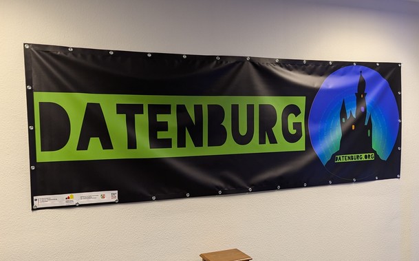 Foto von Schwarzem Banner an der Wand mit Grünem Text: 