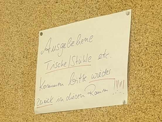 Handgeschriebenes Schild an einer Pinnwand: 